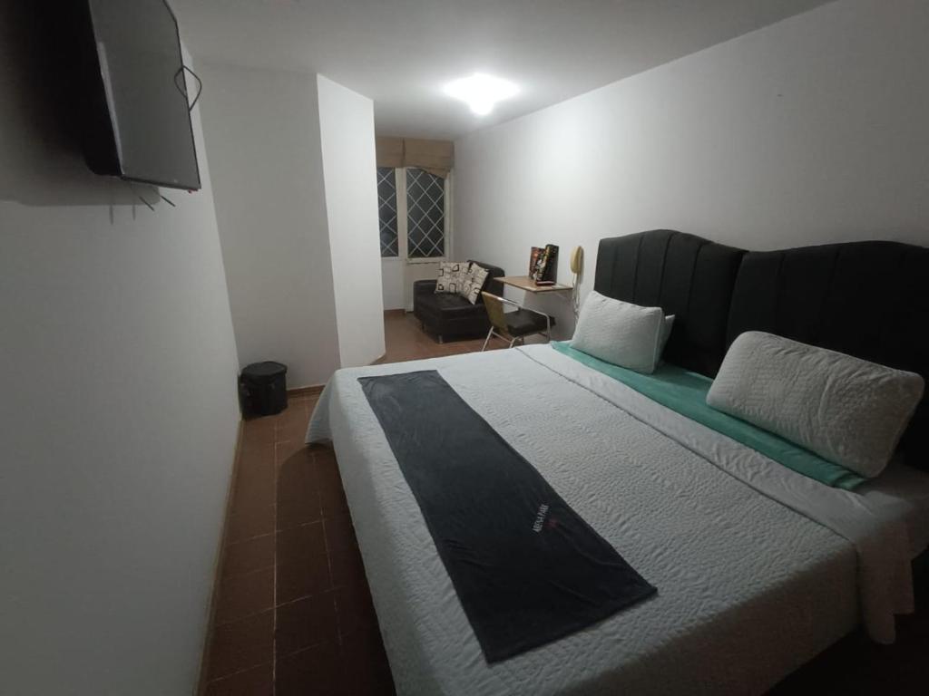 ARENA PARK في بوغوتا: غرفة نوم مع سرير كبير وتلفزيون على الحائط