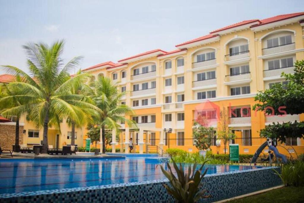 a hotel with a swimming pool in front of a building at Kara's Suite in Cebu City