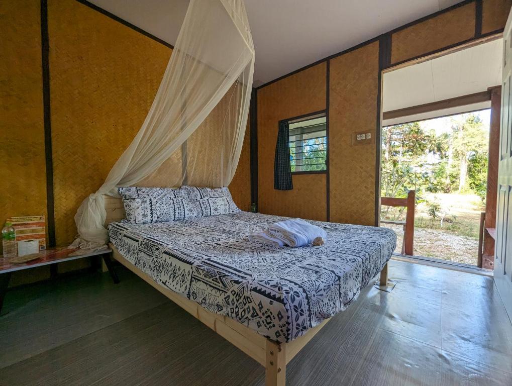 a bedroom with a bed with a canopy at Neverland Beach Village Bungalows in Ko Lanta