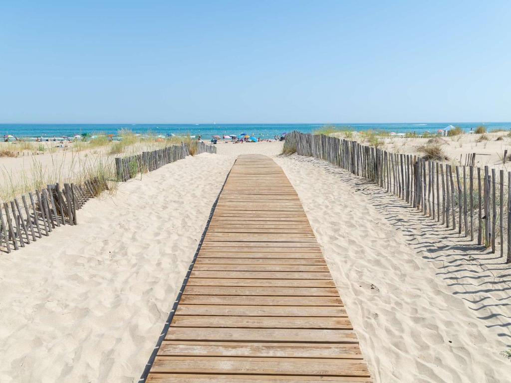 un camino de madera a través de la arena de la playa en Appartement Marseillan-Plage, 2 pièces, 4 personnes - FR-1-387-202, en Marseillan