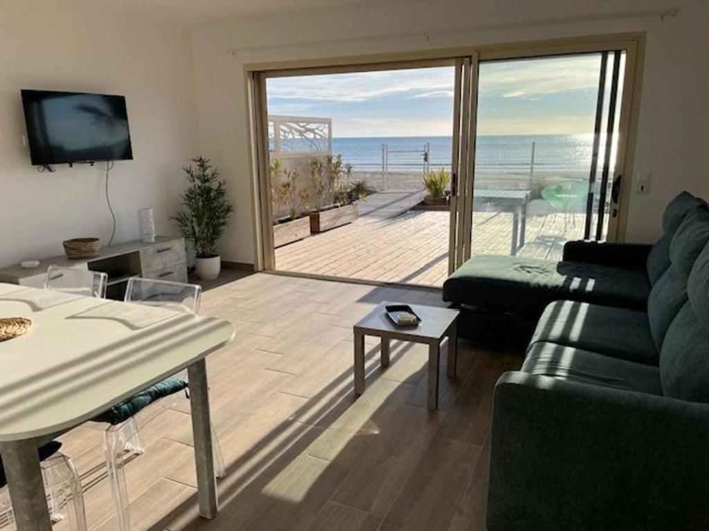 a living room with a couch and a view of the ocean at Villa Agde, 3 pièces, 5 personnes - FR-1-749-40 in Le Grau-dʼAgde