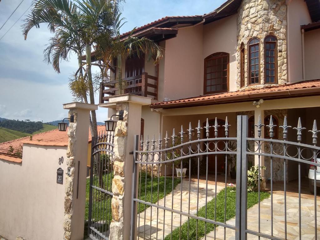 una puerta frente a una casa con una palmera en Pousada Castelinho Conservatória, en Conservatória
