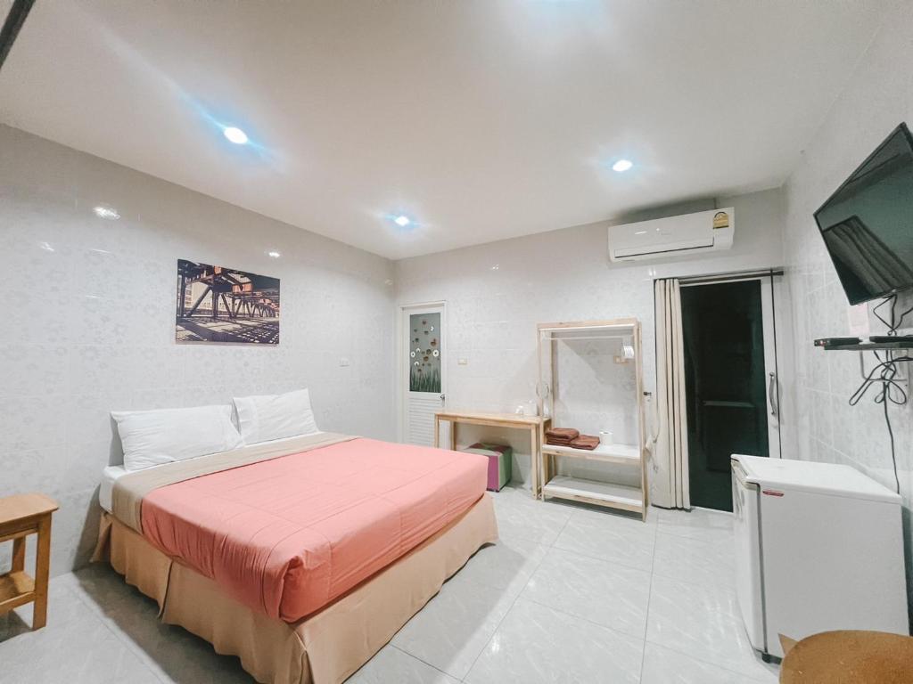 a bedroom with a bed and a flat screen tv at Sirikul Mansion in Nai Yang Beach