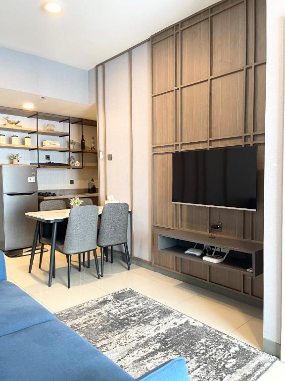 a living room with a dining table and a television at 2 BR I ANDERSON I 22floor I above pakuwon mall I the biggest shopping center in Surabaya