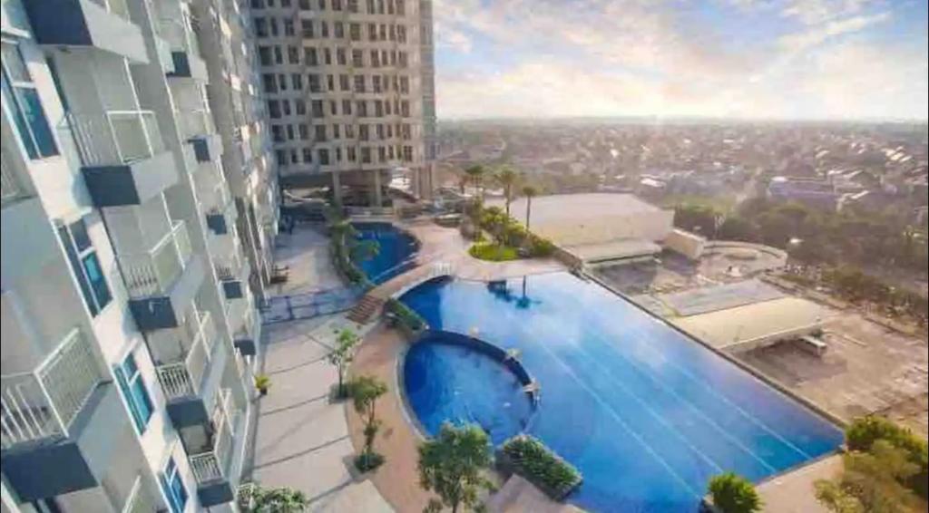 a view of a swimming pool in a building at 2 BR I ANDERSON I 22floor I above pakuwon mall I the biggest shopping center in Surabaya