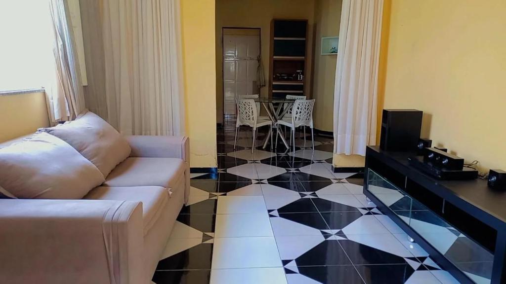 ein Wohnzimmer mit einem Sofa und einem schwarz-weißen Fliesenboden in der Unterkunft Riverside house in Barra dos Coqueiros