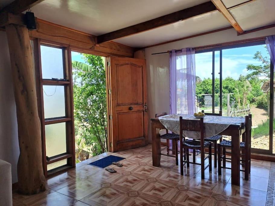 uma sala de jantar com mesa e cadeiras e janelas grandes em Cabañas Hare Tupuna o Piri Nui em Hanga Roa