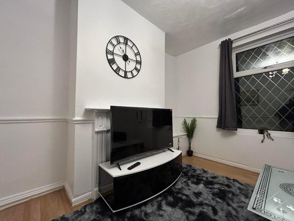 a living room with a large clock on the wall at Comfortable, spacious 2 Bedroom house close to Etihad Stadium in Stalybridge