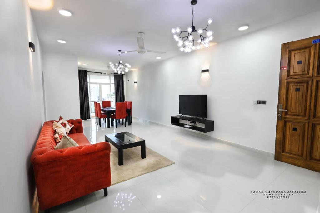 a living room with a red couch and a table at BNB RESIDENCIES MOUNT LAVINIA 2 in Mount Lavinia