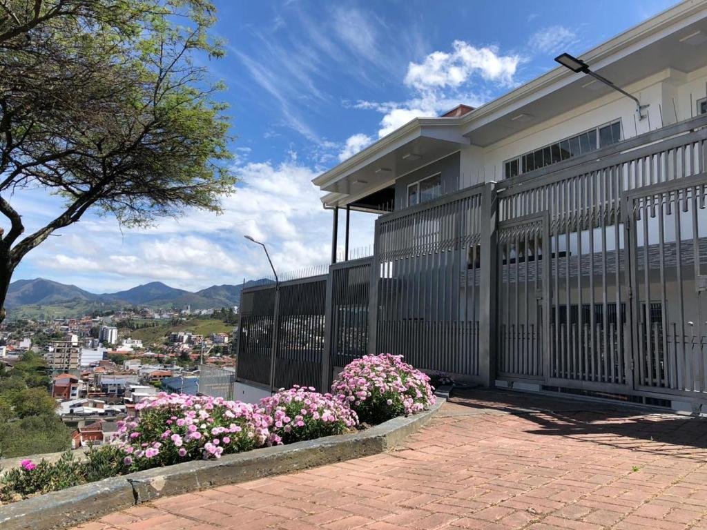 a house with a fence and some flowers at Mirador Departamento in Loja