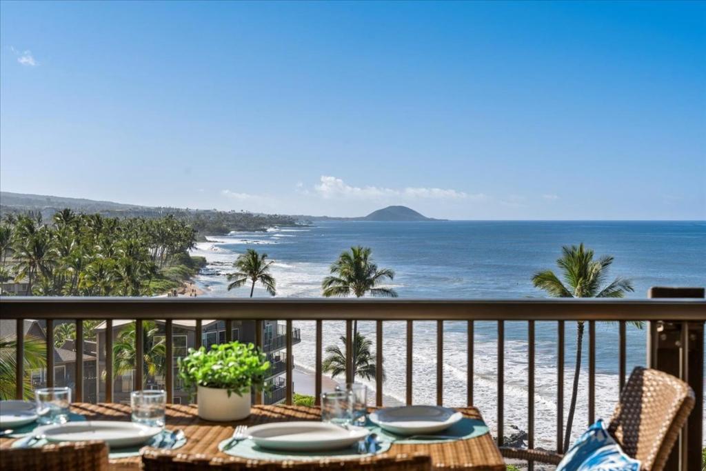 una mesa en un balcón con vistas a la playa en Mana Kai by Coldwell Banker Island Vacations, en Wailea