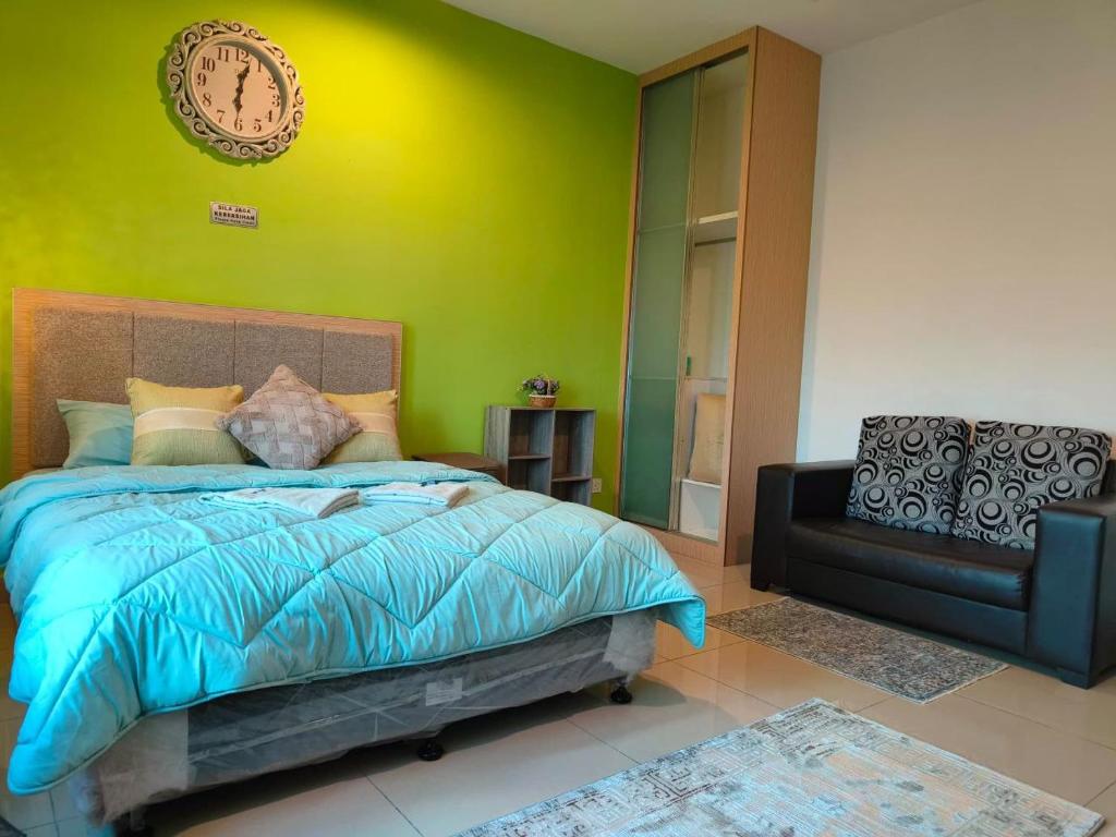 a bedroom with a bed and a clock on the wall at HomeStay De’Viana NMS Residence in Kota Bharu