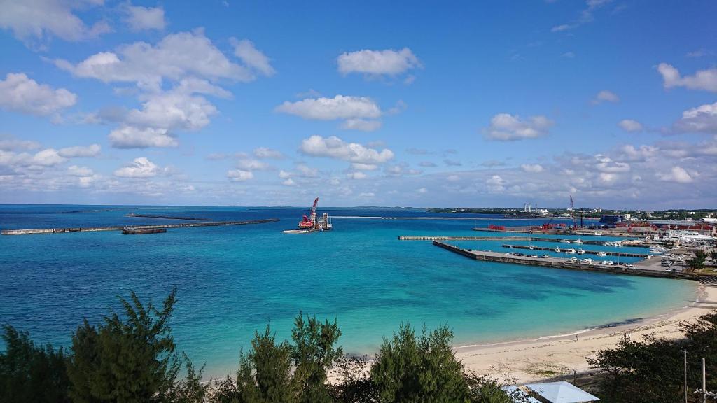 a view of a beach with a boat in the water at Hotel Southern Coast Miyakojima in Miyako-jima