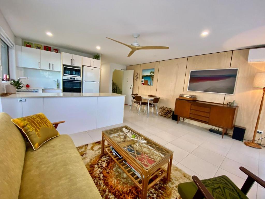 a living room and kitchen with a couch and a table at Lou's Tiki Pad - Beachfront Bilinga North Kirra - Min. 2 Night Stays! in Gold Coast