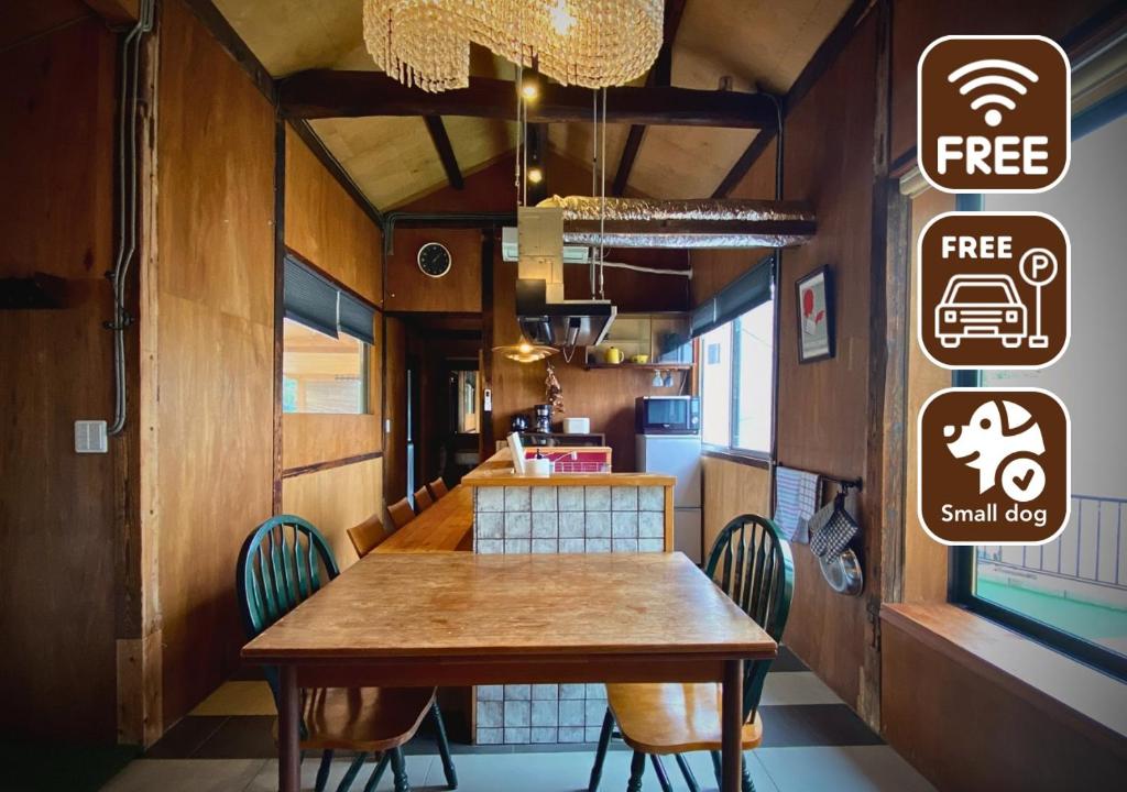 una sala da pranzo con tavolo e sedie in legno di SUMITSUGU HOUSE East a Kumamoto