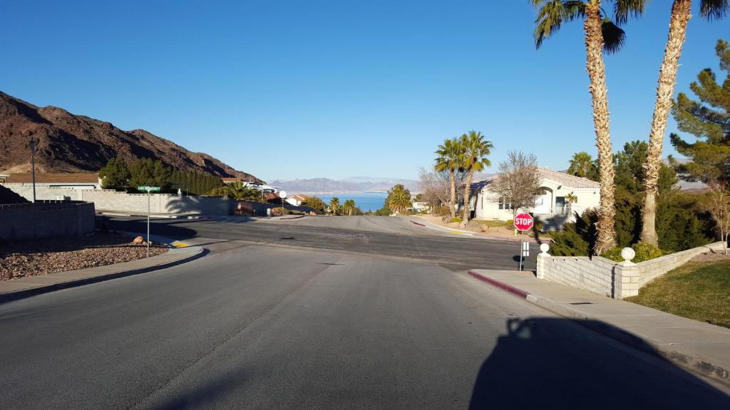 an empty street with a stop sign and palm trees at Not Vegas, But Close Enough in Boulder City