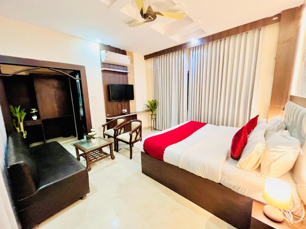 ein Schlafzimmer mit einem Bett, einem Stuhl und einem Sofa in der Unterkunft Hotel Rama, Top Rated and Most Awarded Property In Haridwar in Haridwar