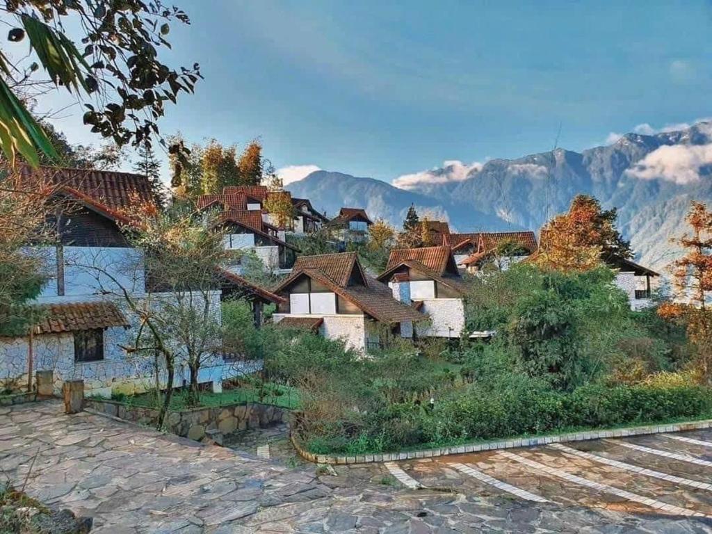 a group of houses with mountains in the background at SAPA JADE HILL( CĂN CHỦ BIỆT THỰ) in Sa Pa