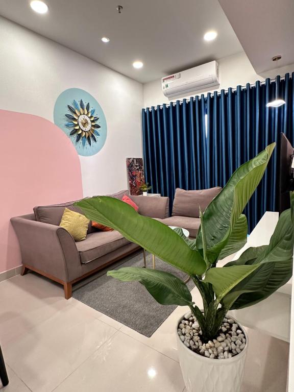 un soggiorno con divano e pianta di QUACH’ HAPPY HOUSE LUXURY 2BRS APARTMENT ad Ho Chi Minh