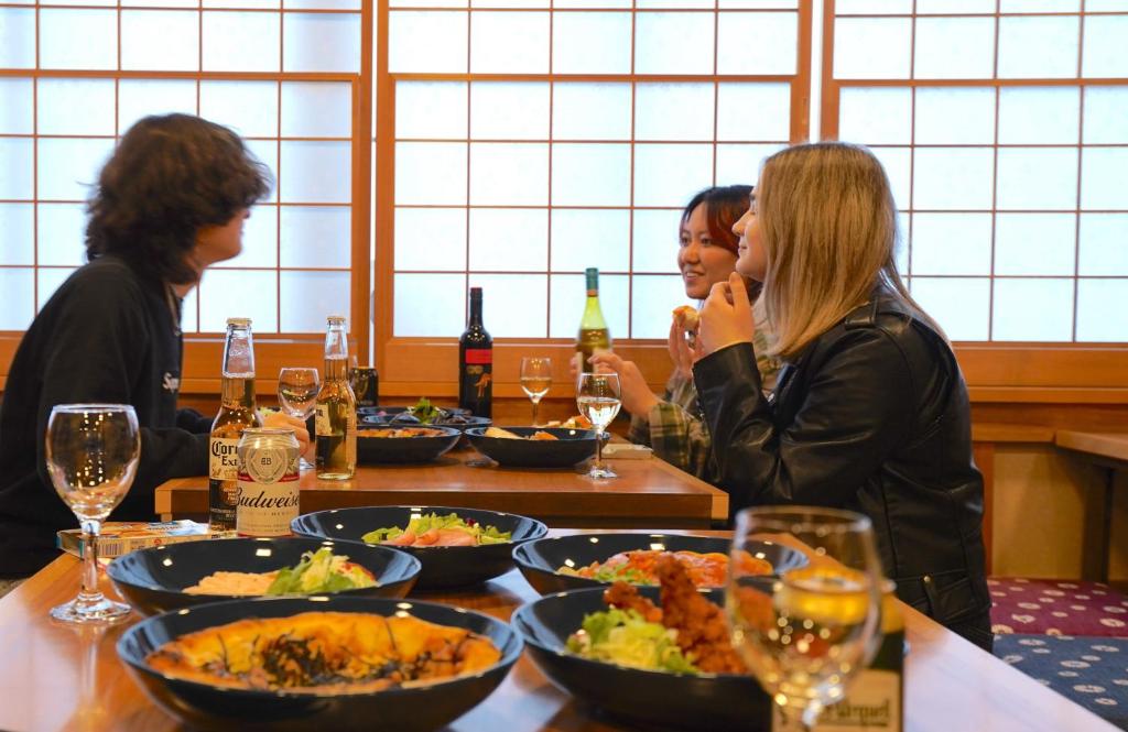 um grupo de mulheres sentadas à mesa com comida em COGO Ryogoku em Tóquio