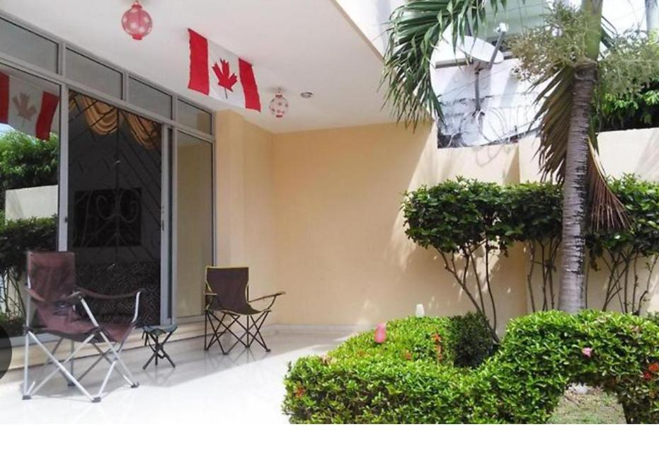 budynek z krzesłami i roślinami przed budynkiem w obiekcie Canadian House Rincón del Mar w mieście Rincón
