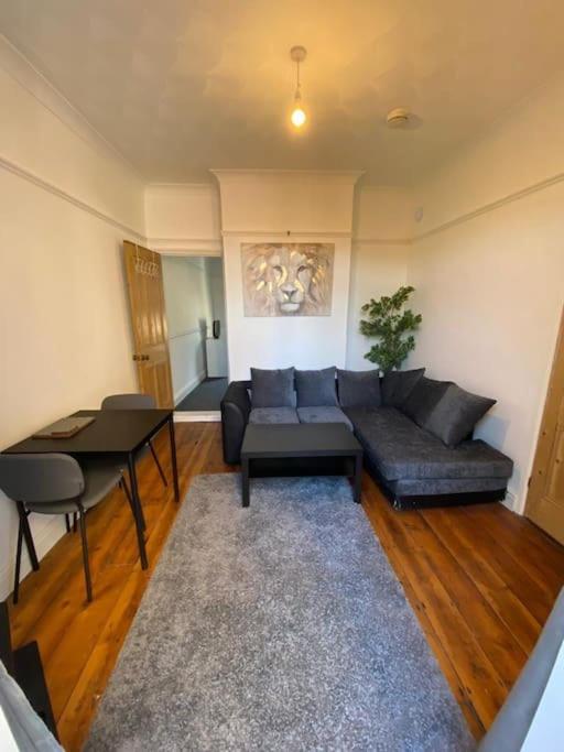 a living room with a couch and a table at One bedroom apartment with garden. in Norwich