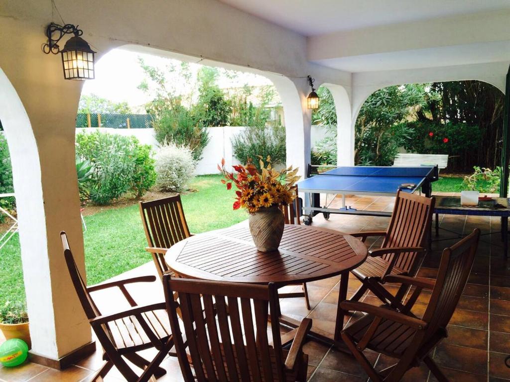 a patio with a table and chairs with a pool table at Family villa with garden next to the beach in Mijas Costa