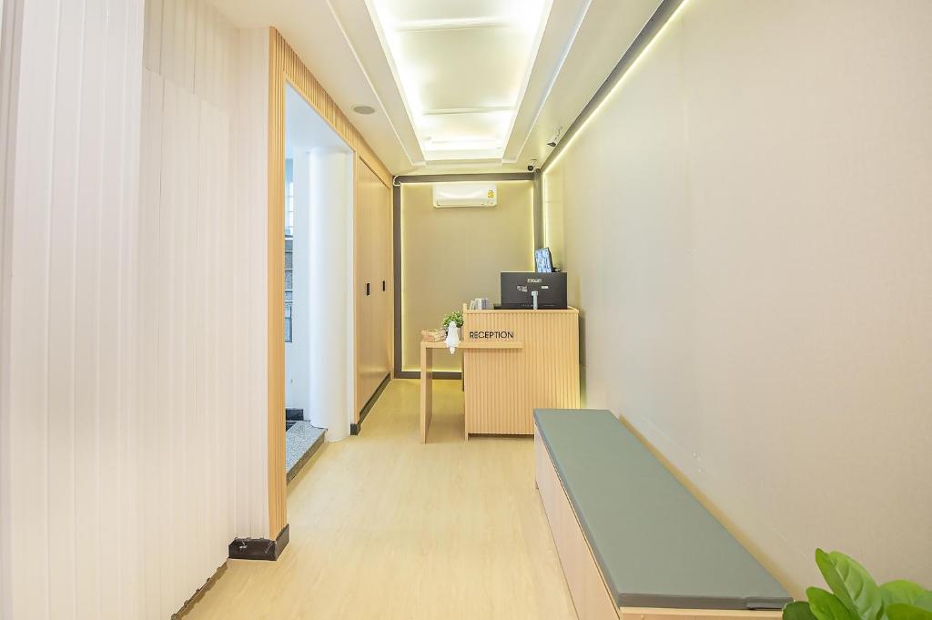 an office corridor with a bench and a desk at Thrive Hotel in Bangkok