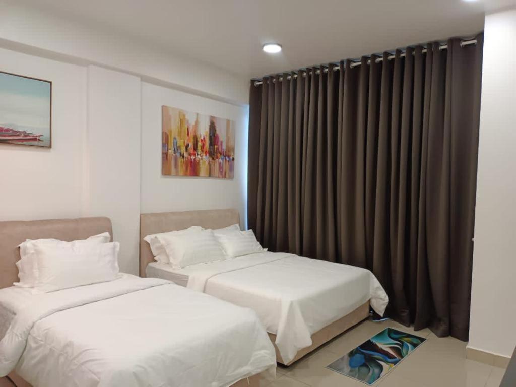 um quarto com 2 camas e uma janela com cortinas em RJ STUDIO APARTMENT 2- Hotel Mutiara em Gua Musang
