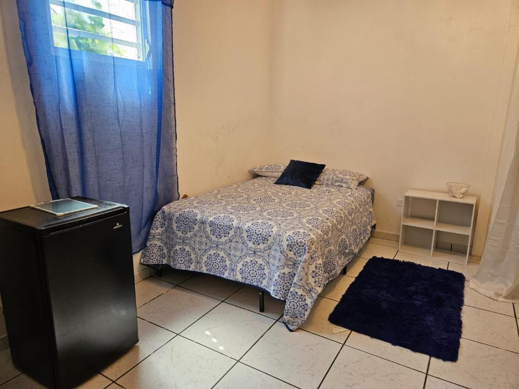 a small bedroom with a bed and a window at Newly remodeled 2nd Floor Unit, 5 BR in Mayaguez