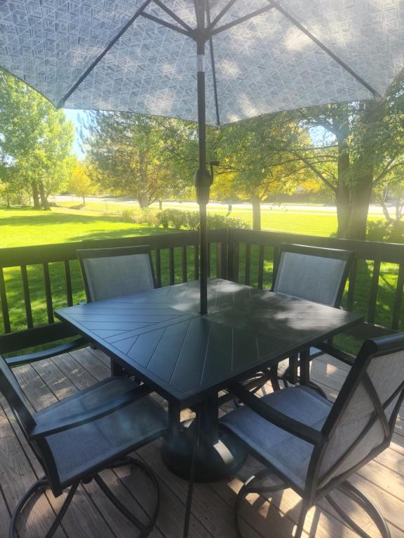 een tafel en stoelen onder een paraplu op een terras bij Happy Home near Downtown Carbondale in Carbondale