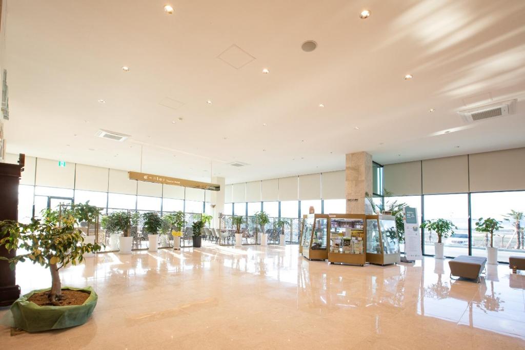 an empty lobby with a tree in the middle of a building at Gangjin K-Stay Tourist Hotel in Kangjin