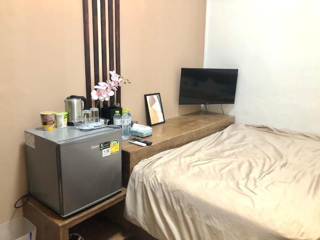 a small room with a bed and a television at nine guesthouse in Ban Pa Tung (7)