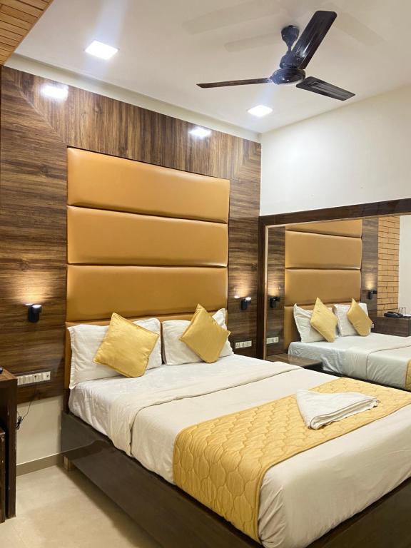 a bedroom with two beds and a ceiling at Hotel Blue Wellington - Near Mumbai Airport in Mumbai