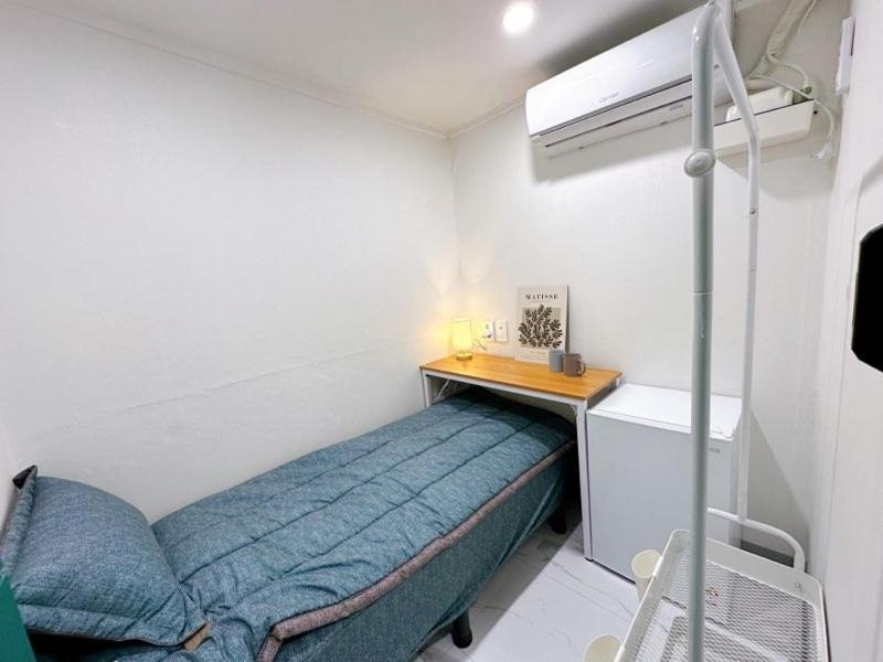 a small bedroom with a bed and a desk at Stay 2002 in Seoul