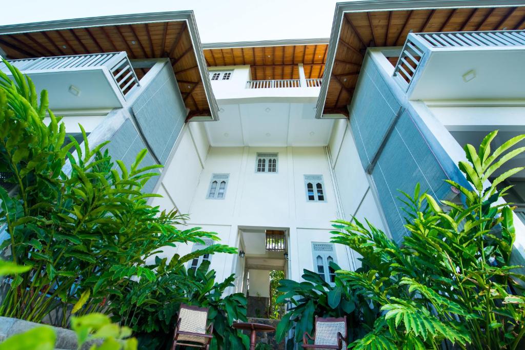 a view of a white building with trees at The Horizon Hill Top Villa in Unawatuna
