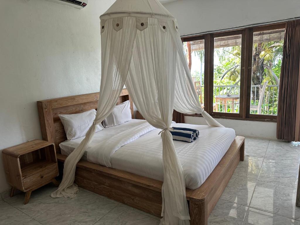a bedroom with a bed with a mosquito net at Azona Greens Uluwatu in Uluwatu
