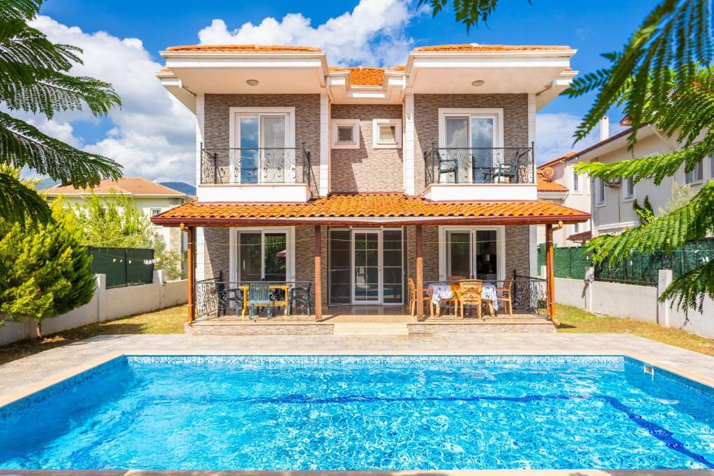 a villa with a swimming pool in front of a house at Villa Magnolia in Dalyan