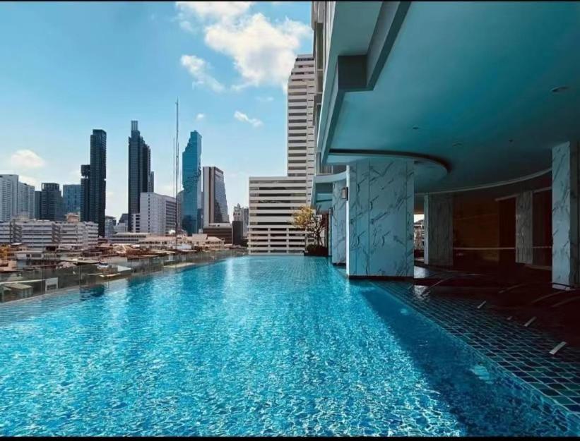 a swimming pool on top of a building with a city skyline at Supalai Bangkok in Bangkok