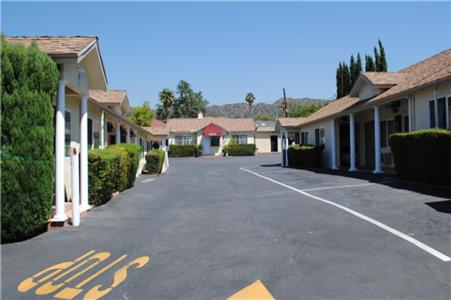 
a street scene with a house and a car at Rose Bowl Motel in Los Angeles
