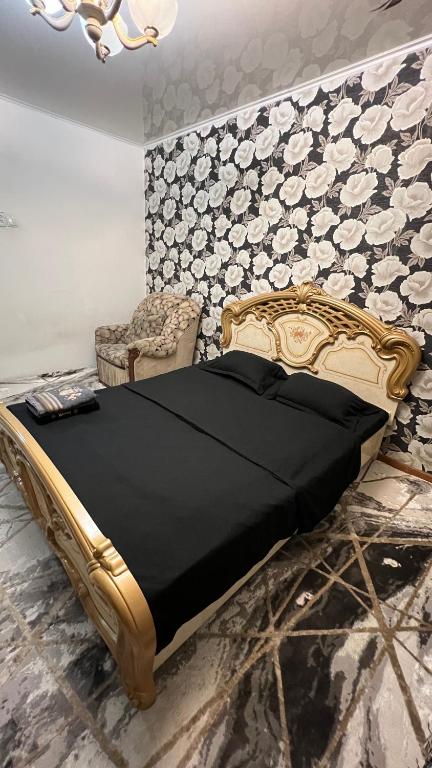 - une chambre avec un lit, une chaise et un mur dans l'établissement Чистая и уютная квартира в 6-ом микрорайоне, à Taraz
