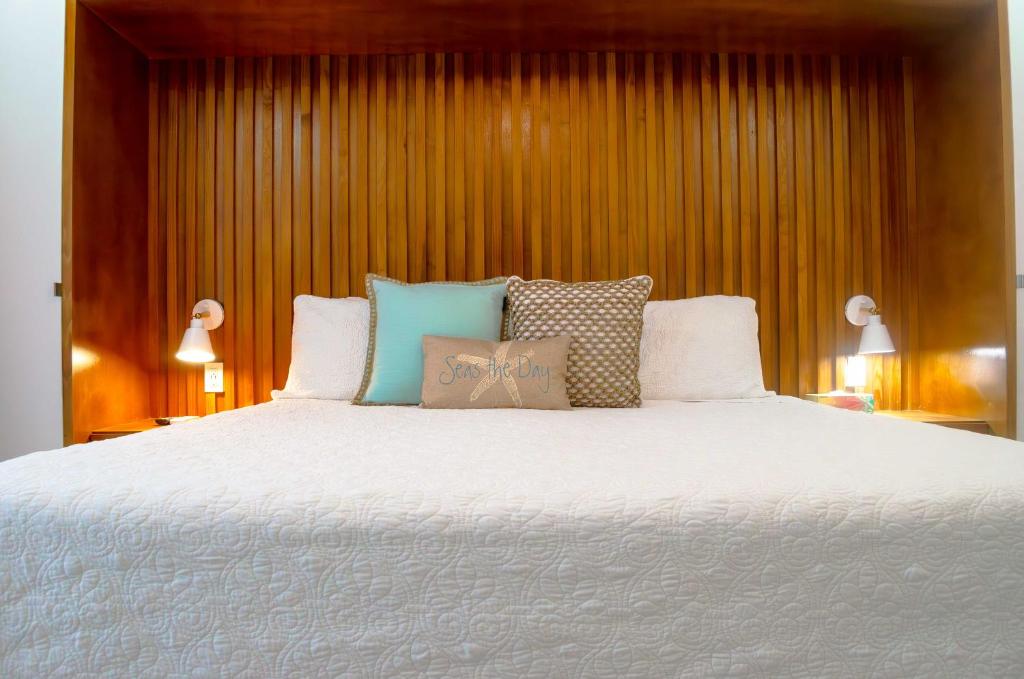 a bedroom with a large white bed with pillows at The Palms Resort in Saint James