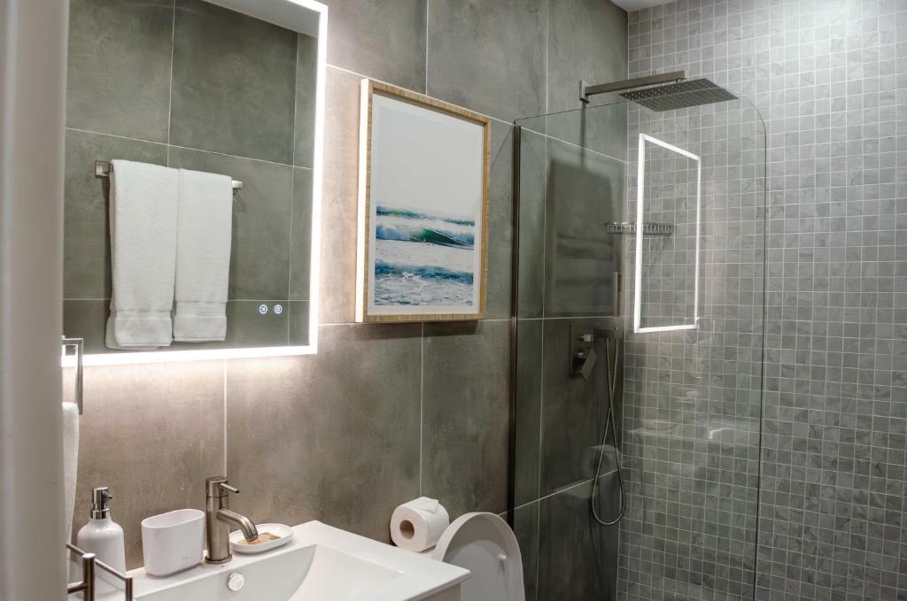 a bathroom with a shower and a sink and a toilet at The Palms Resort in Saint James