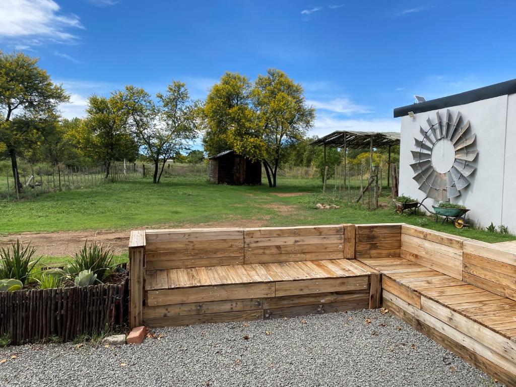 un banc de jardin en bois devant un bâtiment dans l'établissement Le Petit Guesthouse, à Bloemfontein