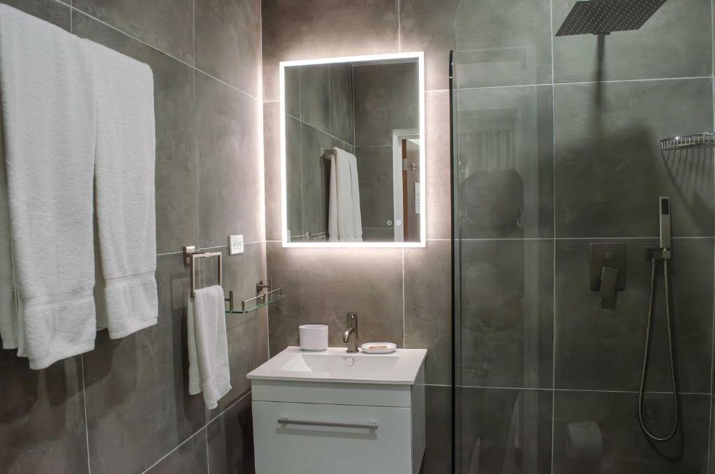 a bathroom with a sink and a shower with a mirror at The Palms Resort in Saint James