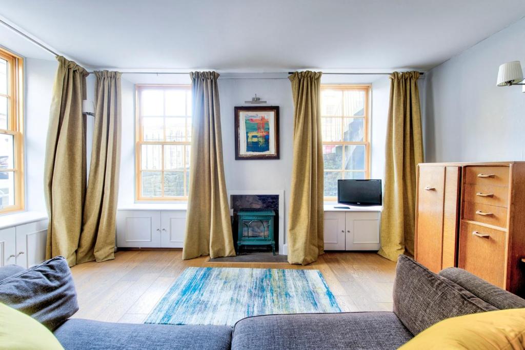 a living room with a couch and two windows at GuestReady - Edinburgh's New Town Cosy Hideaway in Edinburgh