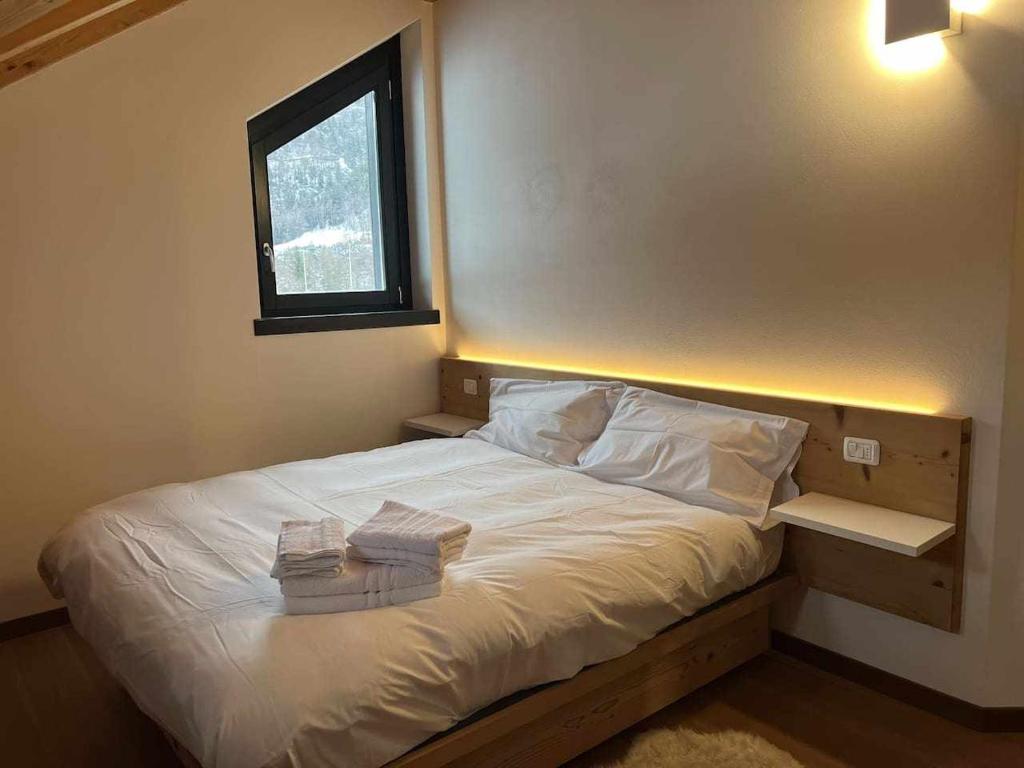 1 dormitorio con 1 cama con 2 toallas en Casa Giuliana con SkiBus Gratis, en Aprica