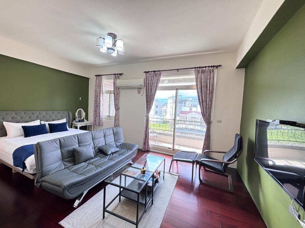 a bedroom with a bed and a couch and a tv at 伊家民宿Yi home 志航路一段398號 in Taitung City