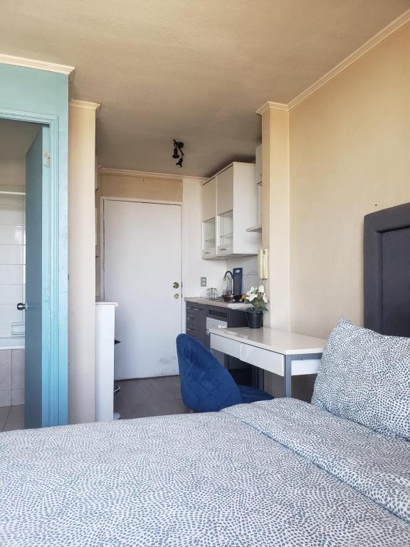 聖地亞哥的住宿－Suit vista despejada，一间带一张床和一张书桌的卧室和一间厨房