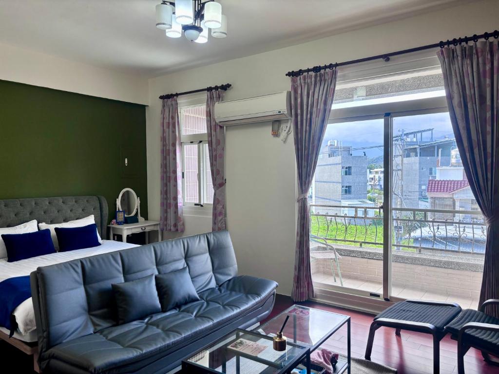 a bedroom with a couch and a large window at 伊家民宿Yi home 志航路一段398號 in Taitung City